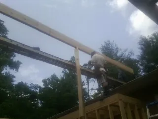 Carpenter setting a ridge beam over a new addition frame — Ice Dam Removal by Roofing Brothers in Wentzville