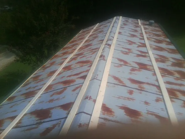 Rusted metal roof panels with new wood purlins before replacement — Storm Damage Roof Repair in Wentzville by Roofing Brothers