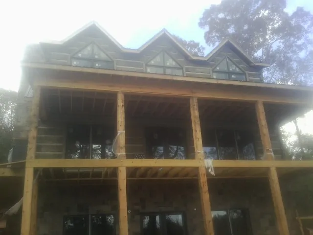 Dormers and porch framing on a large log home under construction — Roof Coating work by our crew in Wentzville