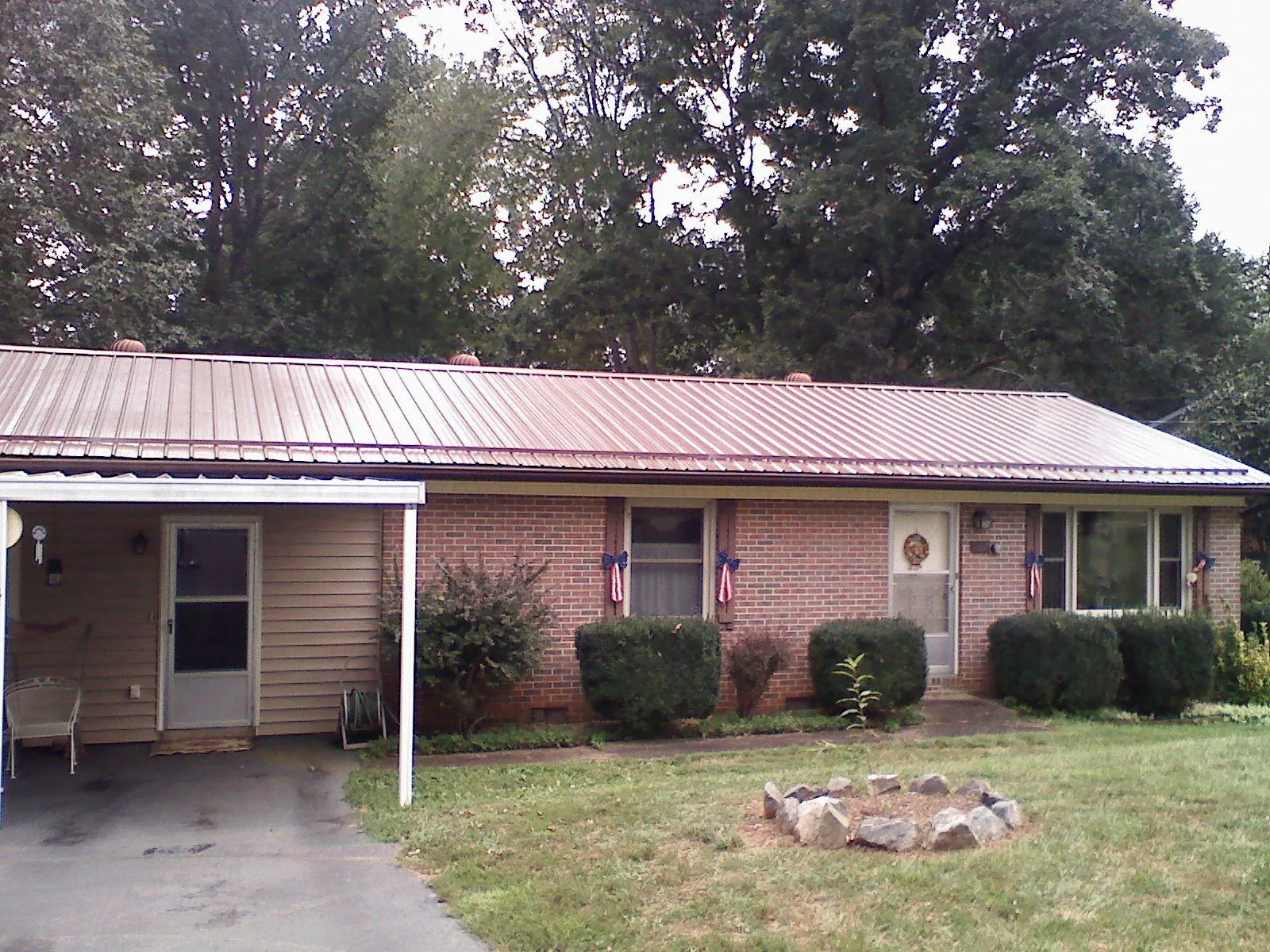 Bronze metal roof and carport on a brick ranch home — Roof Repair work by our crew in Wentzville